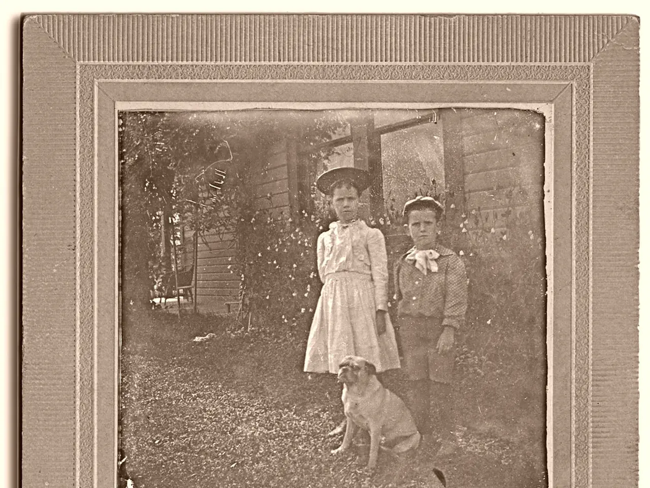 In this picture we can see a photo with photo frame. In the photo we can see a dog and two kids...