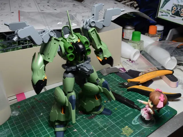 In this image we can see toys, a cutter, box, few bottles, a screen, papers and few other objects...