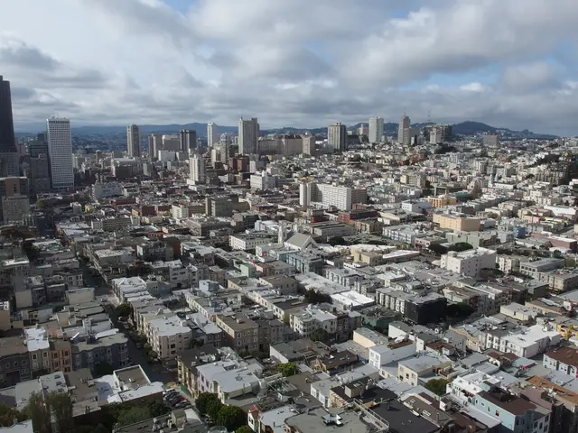 It is an image of a well developed city, there are plenty of houses, buildings and tall towers,...