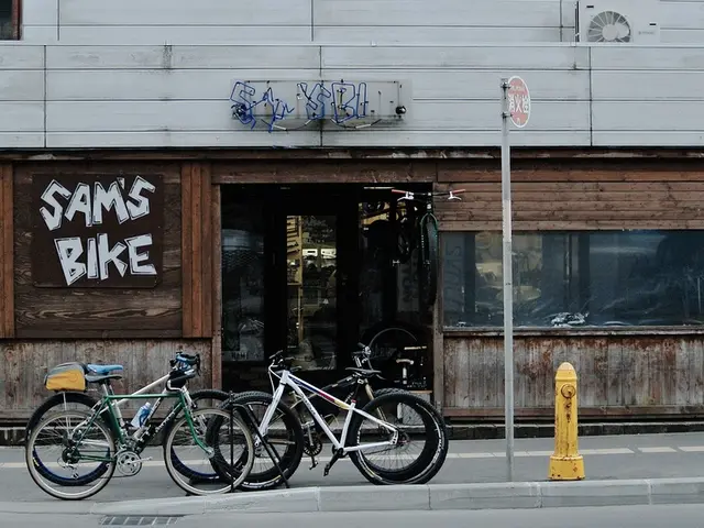 In the image it looks like there is a store and in front of the store there are cycles, a pole and...
