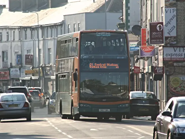 At the bottom of the image there is a road with cars and a bus. Behind them there are buildings...